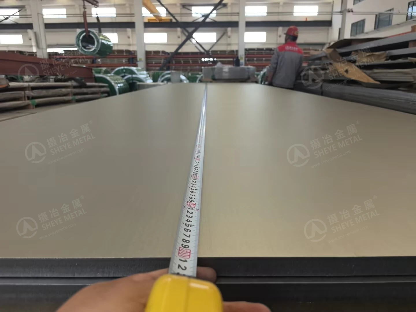 A measuring tape extended along a 2507 stainless steel plate in the Sheye Metal workshop.