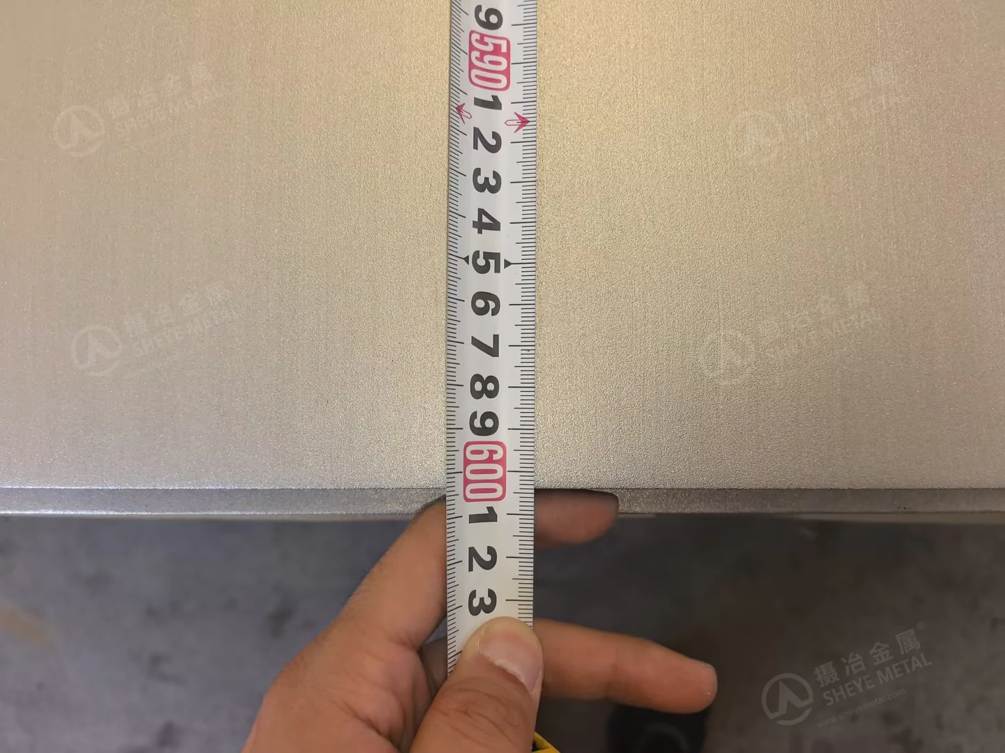 Close-up of the measuring tape near the end of a nominal 6000 mm stainless steel plate.