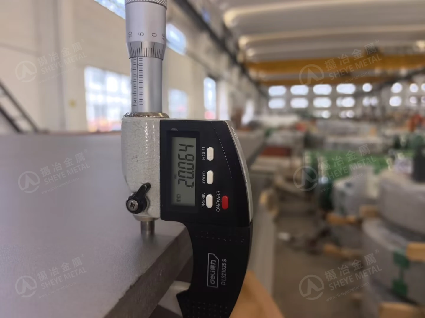Digital micrometer measuring the thickness of a 2507 stainless steel plate at Sheye Metal.