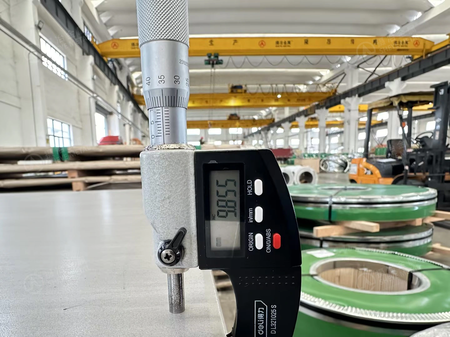 Digital micrometer checking another point on the nominal 10 mm 310S hot rolled plate.