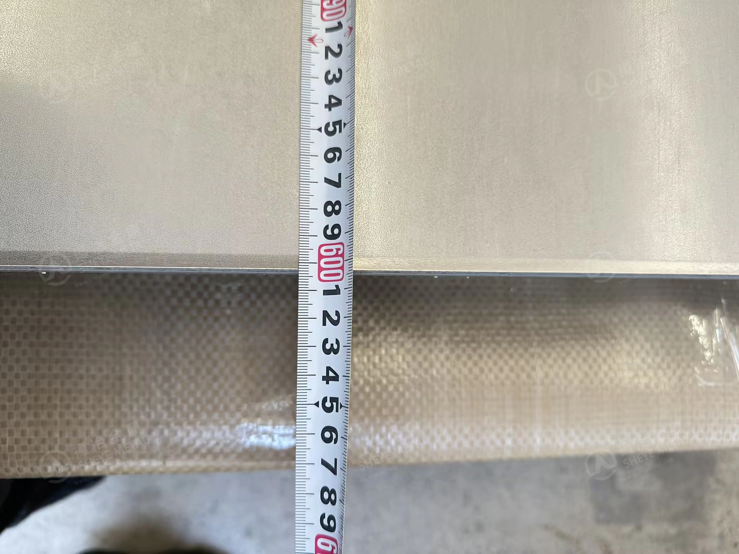 Close-up of the tape at the end of the nominal 6000 mm long, 12 mm 310S plate.