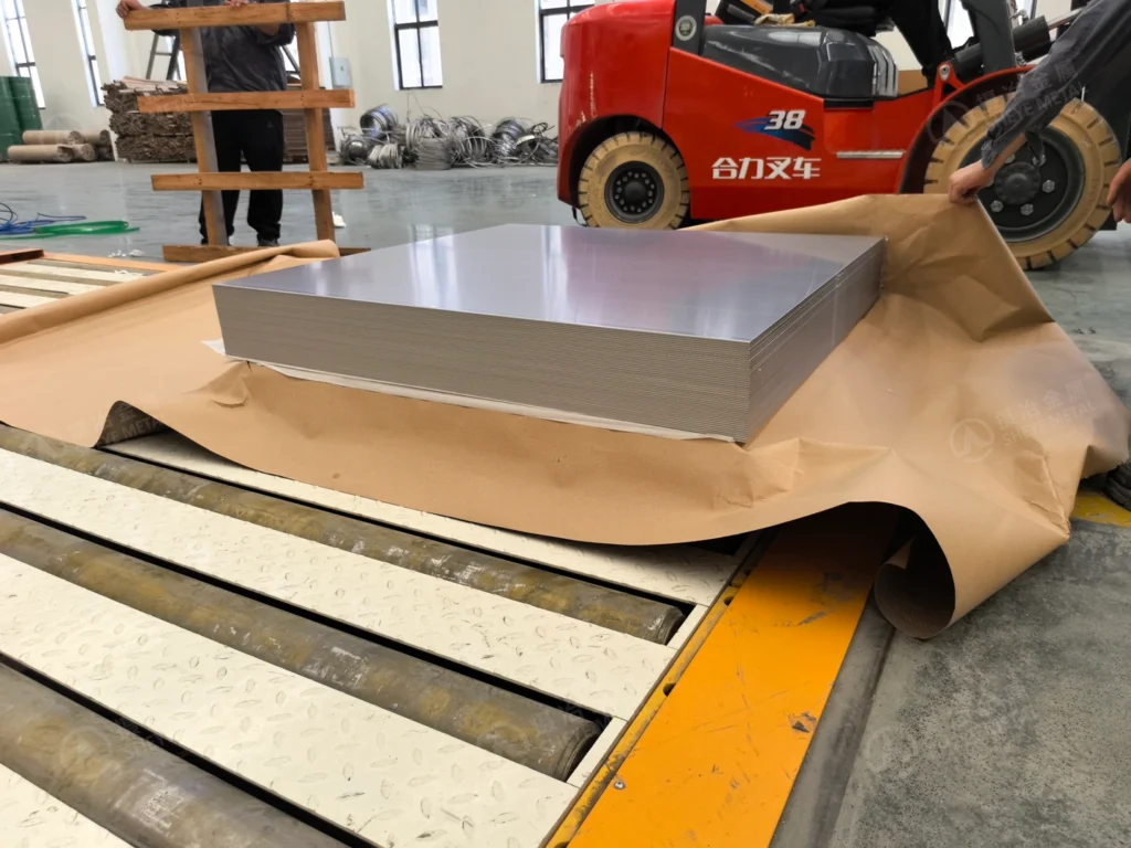 Cut stainless steel cathode sheets stacked on protective packing paper at Sheye Metal.