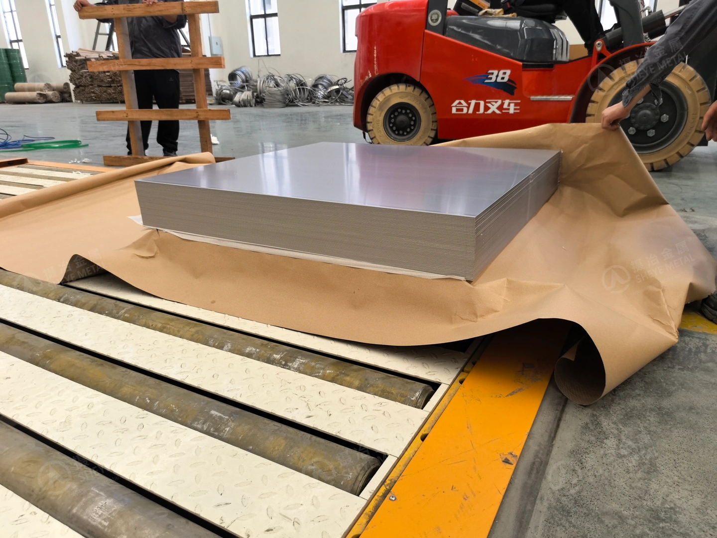 Cut stainless steel cathode sheets stacked on protective packing paper at Sheye Metal.